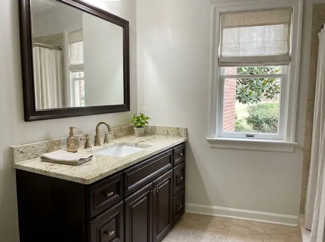 Illustration of a bathroom vanity with a cream granite top and dark wood cabinet